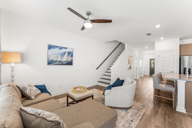 living room featuring ceiling fan and dark wood-type flooring