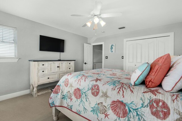 bedroom with ceiling fan, a closet, and light carpet