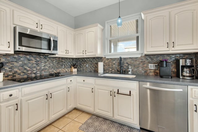 kitchen with backsplash, light tile patterned flooring, sink, and appliances with stainless steel finishes