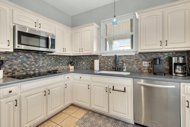 7646 Gulf Blvd, Navarre, FL 32566 - kitchen featuring stainless steel appliances, dark countertops, backsplash, light tile patterned flooring, and pendant lighting