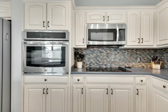 kitchen featuring decorative backsplash, white cabinetry, and appliances with stainless steel finishes