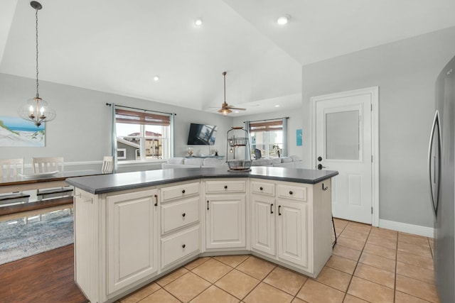 7646 Gulf Blvd, Navarre, FL 32566 - kitchen with vaulted ceiling, dark countertops, a chandelier, a ceiling fan, and freestanding refrigerator