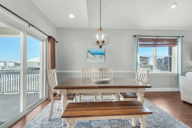 dining space with hardwood / wood-style floors and an inviting chandelier