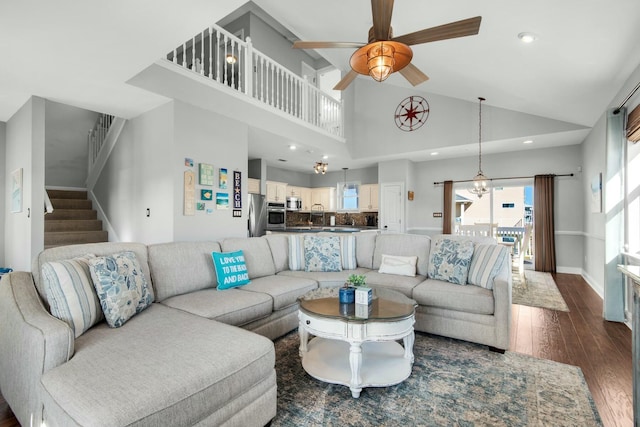 living room with dark hardwood / wood-style flooring, high vaulted ceiling, and ceiling fan with notable chandelier