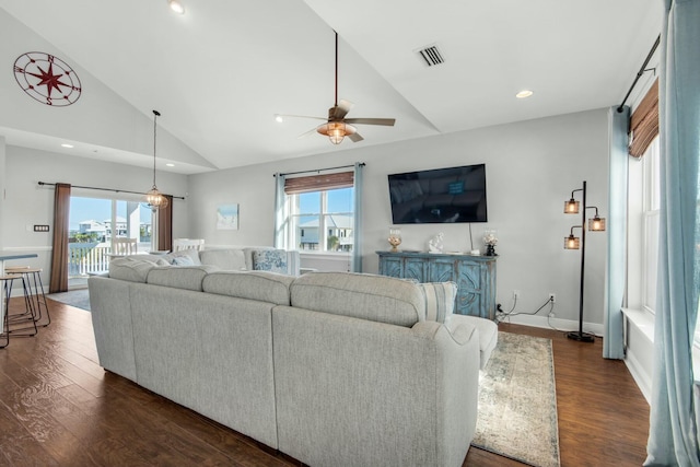 living room with ceiling fan, high vaulted ceiling, a healthy amount of sunlight, and dark hardwood / wood-style floors