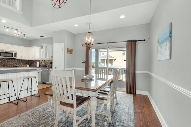 dining area featuring a chandelier, sink, and wood-type flooring