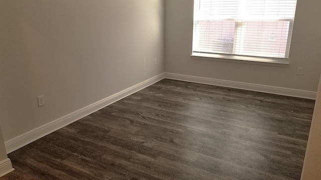 empty room with dark hardwood / wood-style flooring