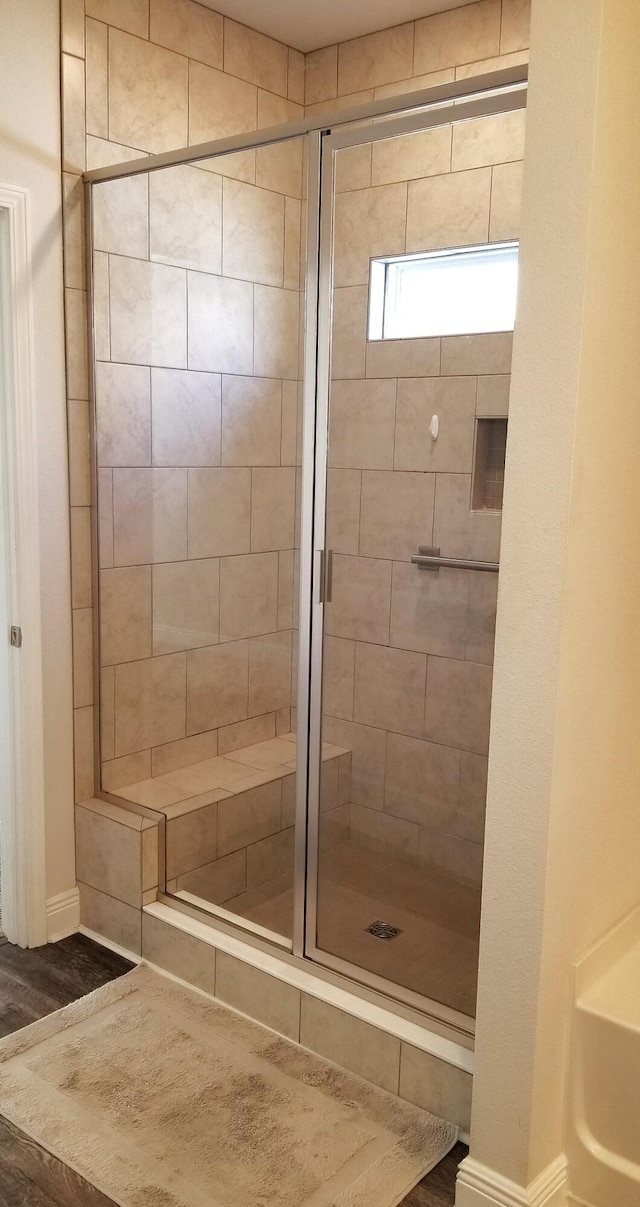 bathroom with hardwood / wood-style floors and tiled shower