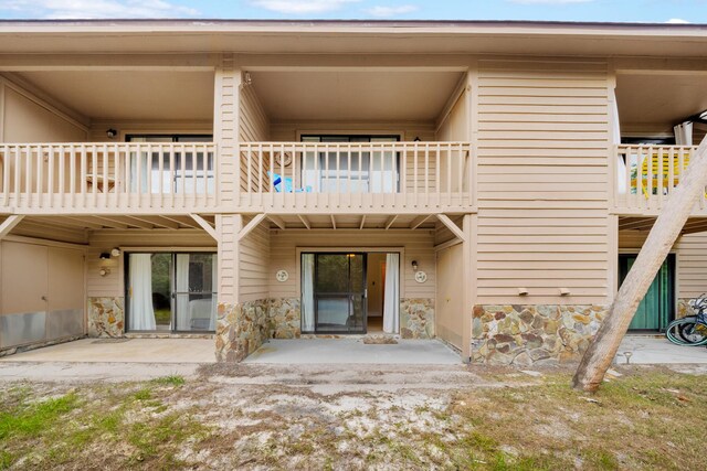 rear view of house featuring a balcony and a patio