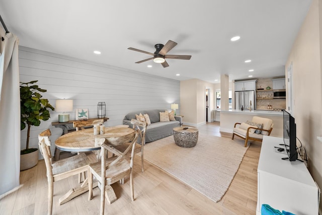 dining space featuring ceiling fan and light wood-type flooring