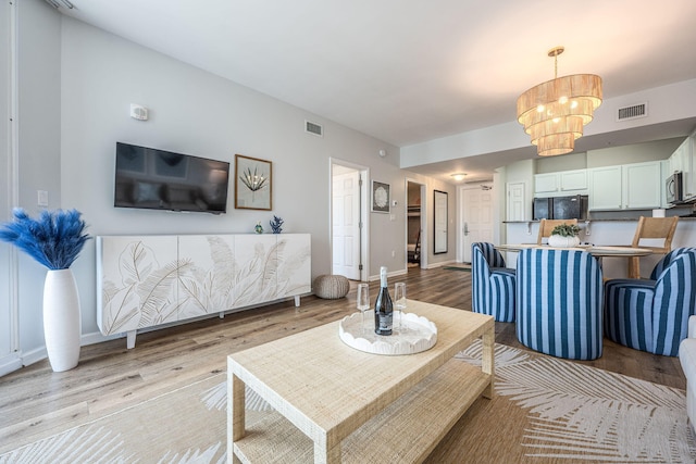 living room featuring light hardwood / wood-style flooring and a notable chandelier