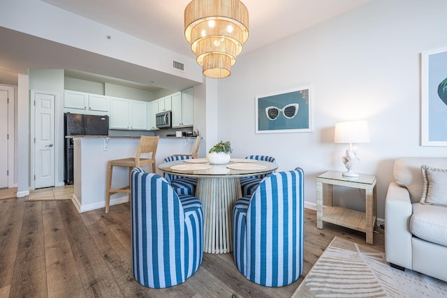 dining room with hardwood / wood-style flooring and a chandelier