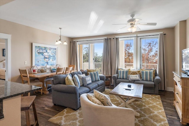 living room with dark hardwood / wood-style floors and ceiling fan with notable chandelier