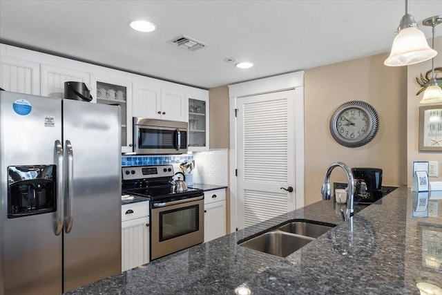 kitchen with white cabinetry, sink, pendant lighting, and stainless steel appliances