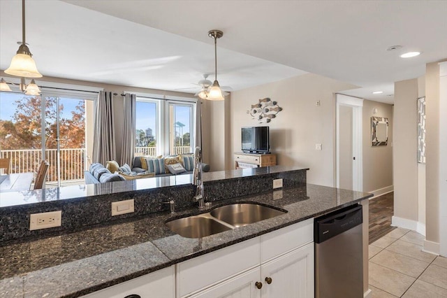 kitchen with sink, decorative light fixtures, dark stone countertops, dishwasher, and white cabinets