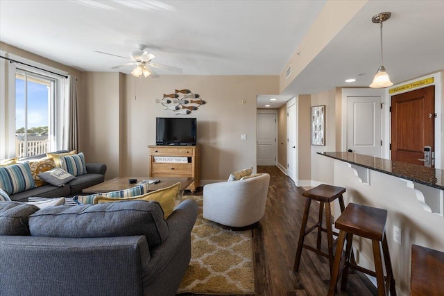 living room with ceiling fan and dark hardwood / wood-style floors