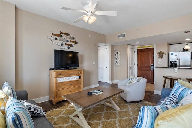 living room featuring dark wood-type flooring and ceiling fan