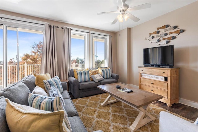 living room featuring dark wood-type flooring and ceiling fan