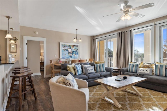 living room featuring dark hardwood / wood-style flooring and ceiling fan with notable chandelier