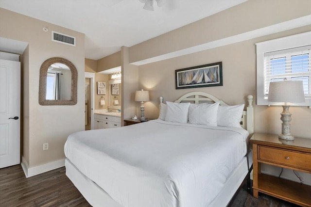 bedroom featuring ensuite bath and dark hardwood / wood-style floors