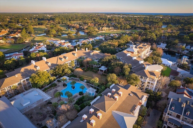 aerial view at dusk featuring a water view