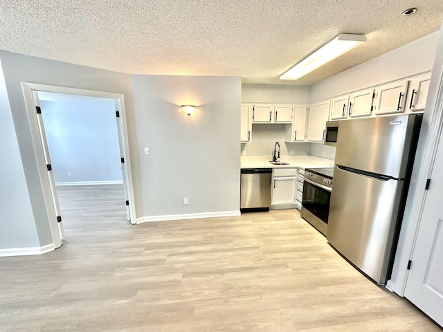 kitchen with white cabinetry, light hardwood / wood-style flooring, sink, and appliances with stainless steel finishes