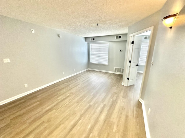 empty room featuring light hardwood / wood-style flooring and a textured ceiling