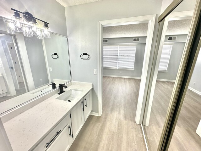 bathroom with vanity, a textured ceiling, and hardwood / wood-style flooring