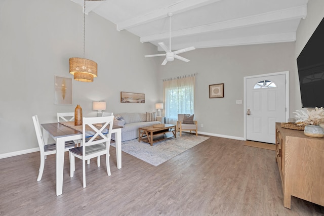 dining space with hardwood / wood-style floors, lofted ceiling with beams, and ceiling fan