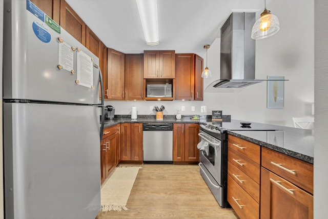 kitchen with decorative light fixtures, light wood-type flooring, stainless steel appliances, and extractor fan