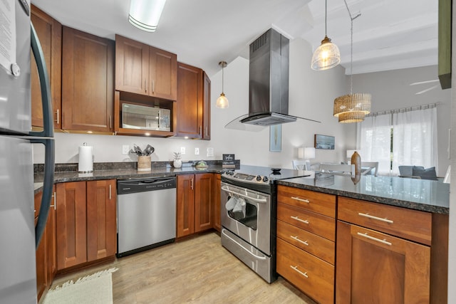 kitchen featuring pendant lighting, light hardwood / wood-style floors, range hood, and appliances with stainless steel finishes