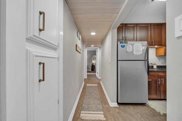 hall featuring light hardwood / wood-style floors and wooden ceiling