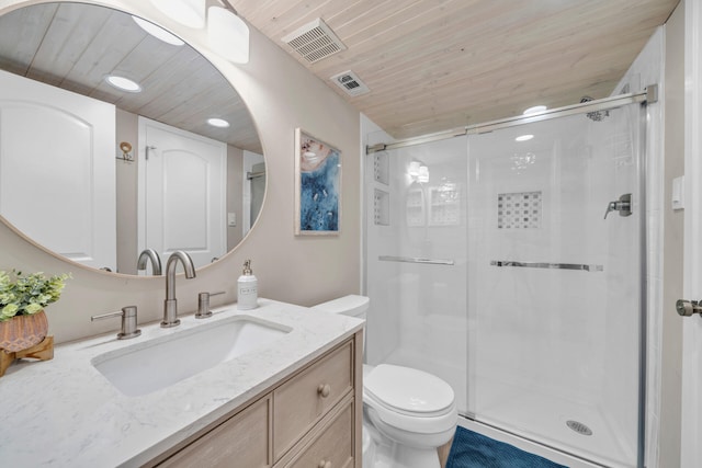 bathroom featuring a shower with door, vanity, and toilet