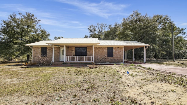 view of front of home with driveway, a porch, a carport, and brick siding