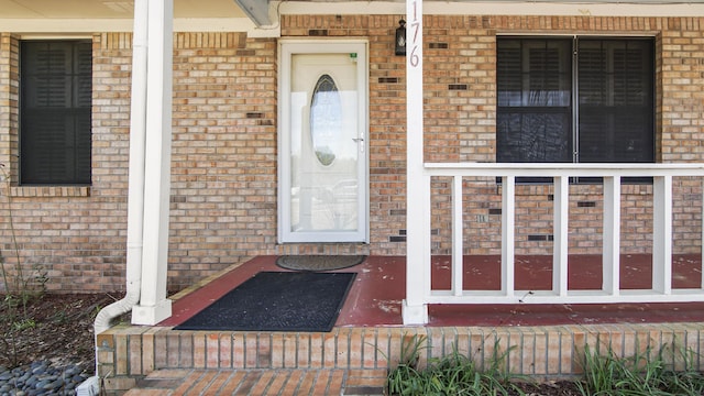 doorway to property featuring brick siding