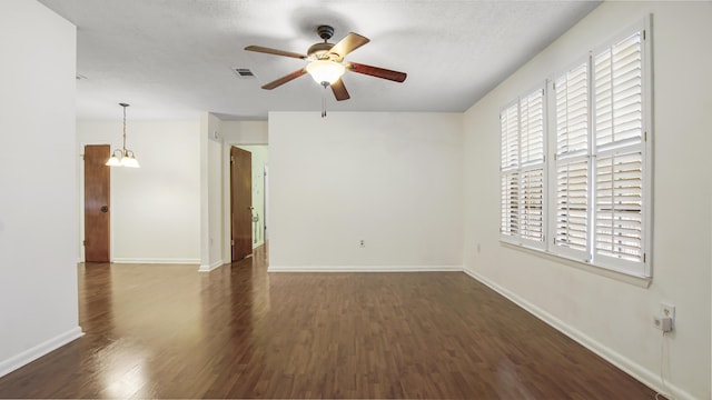 empty room featuring visible vents, baseboards, ceiling fan, wood finished floors, and a textured ceiling