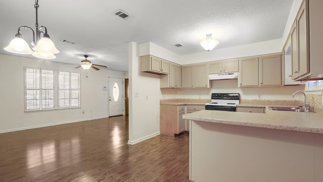 kitchen featuring light countertops, visible vents, a sink, range with electric cooktop, and under cabinet range hood