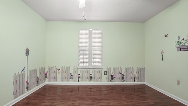 empty room featuring baseboards and wood finished floors