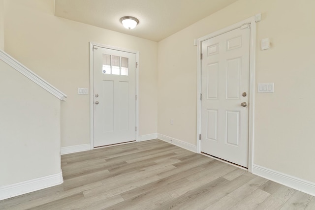 foyer featuring a textured ceiling and light wood-type flooring