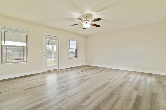 empty room featuring ceiling fan, a healthy amount of sunlight, and light hardwood / wood-style floors