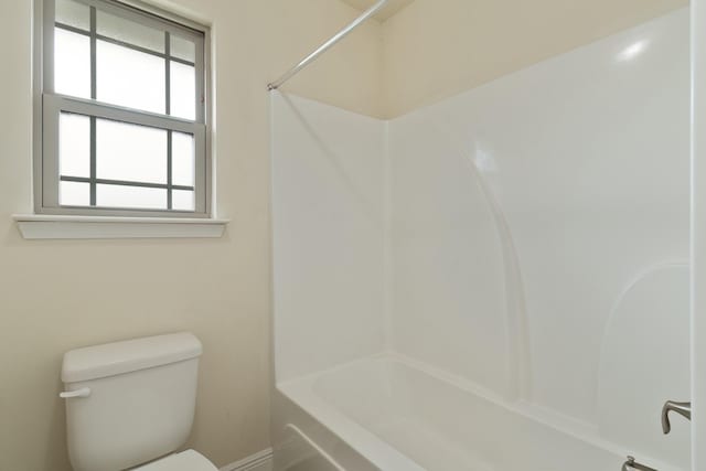 bathroom with shower / bathing tub combination and toilet