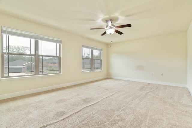 carpeted spare room featuring ceiling fan