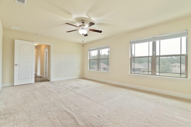 spare room featuring ceiling fan and light carpet