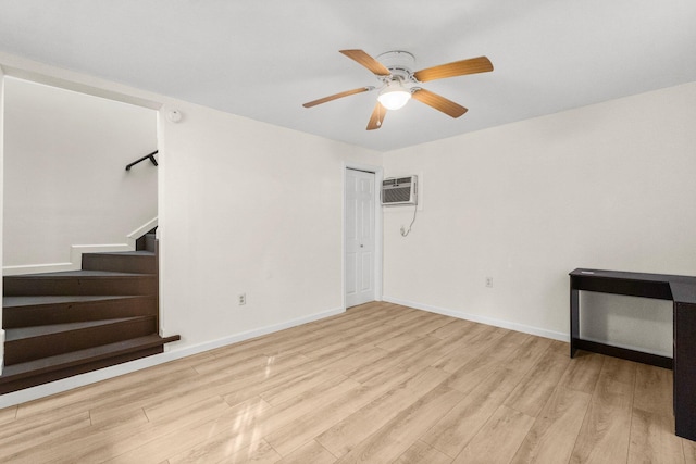 unfurnished room with a wall mounted air conditioner, ceiling fan, and light hardwood / wood-style floors