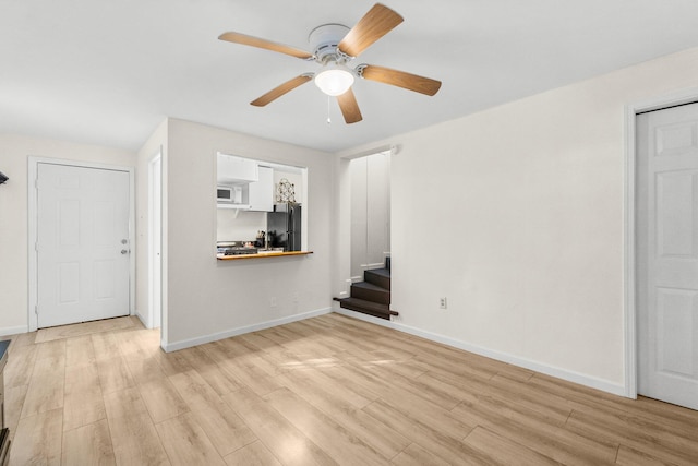 unfurnished living room featuring ceiling fan and light wood-type flooring