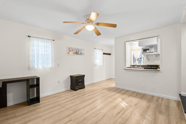 unfurnished living room featuring ceiling fan and light hardwood / wood-style floors