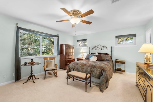 carpeted bedroom with multiple windows and ceiling fan