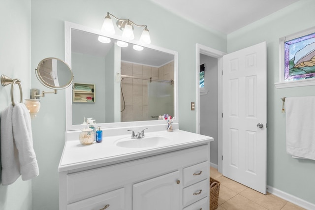 bathroom featuring tile patterned floors, vanity, and a tile shower