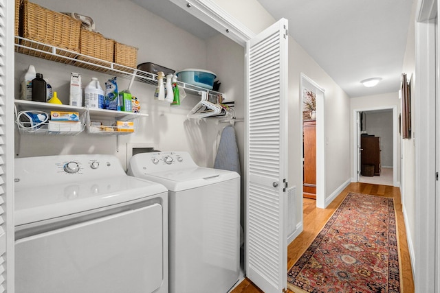 washroom with light hardwood / wood-style floors and washing machine and clothes dryer