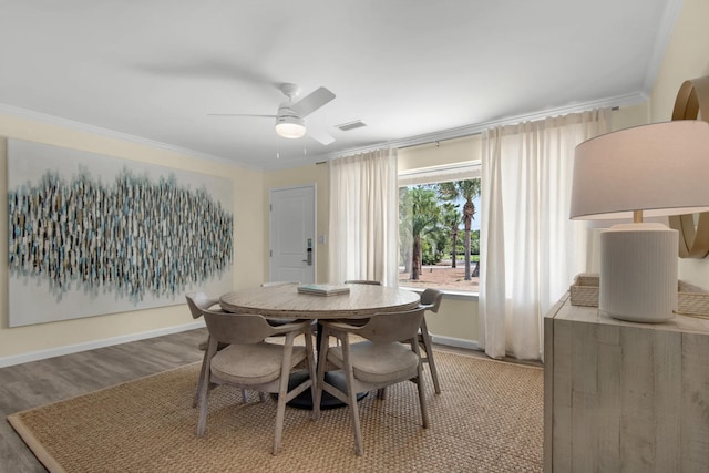 dining room with light hardwood / wood-style floors, ceiling fan, and ornamental molding